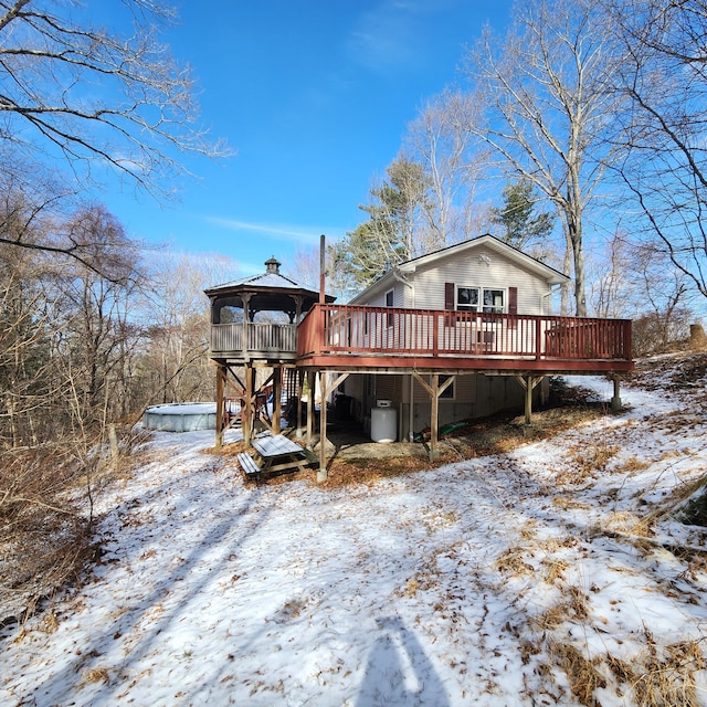 snow covered rear of property with a gazebo and a deck