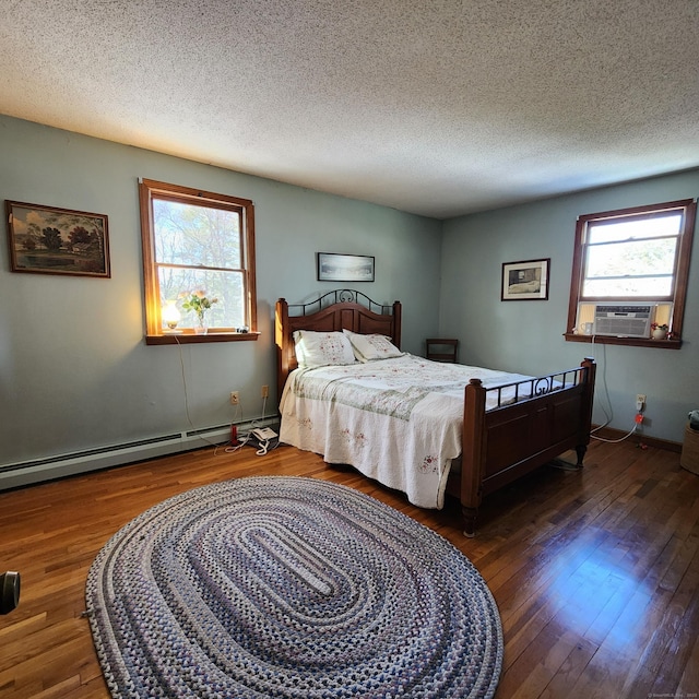 bedroom featuring multiple windows, a baseboard heating unit, a textured ceiling, and dark hardwood / wood-style floors