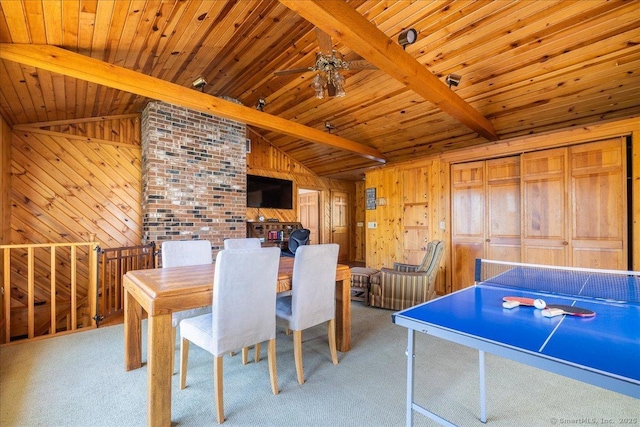 carpeted dining room with wood ceiling, ceiling fan, wooden walls, and lofted ceiling with beams