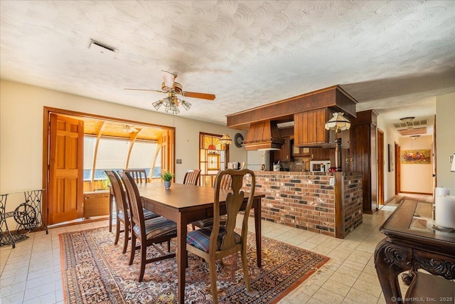 dining room featuring ceiling fan and a textured ceiling