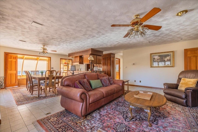 tiled living room with ceiling fan and a textured ceiling