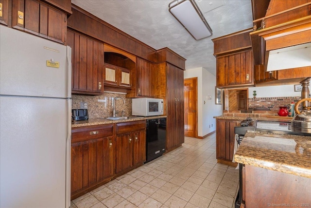 kitchen with tasteful backsplash, sink, white appliances, light stone countertops, and a textured ceiling