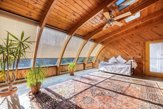 bedroom with a baseboard heating unit, wooden walls, and lofted ceiling with skylight