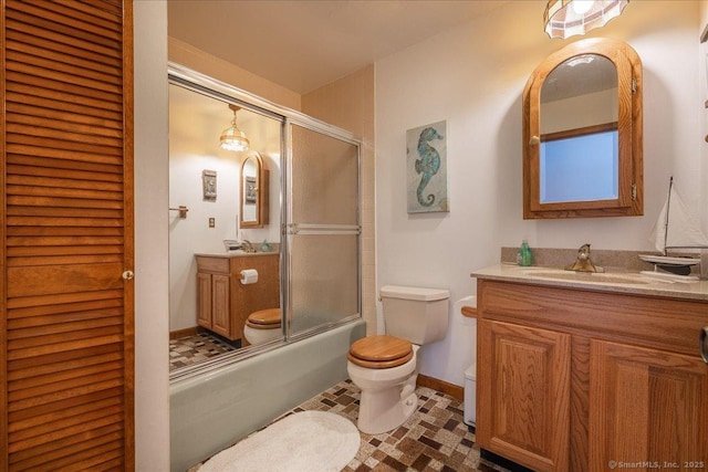 full bathroom with vanity, combined bath / shower with glass door, and toilet