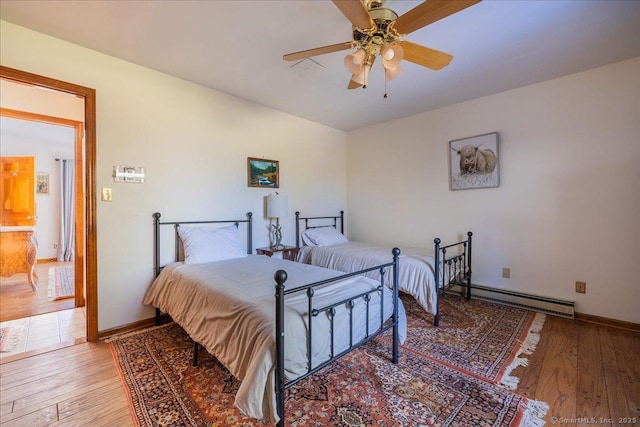 bedroom with a baseboard heating unit, hardwood / wood-style floors, and ceiling fan