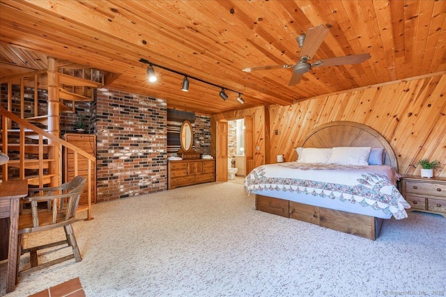 carpeted bedroom with wood ceiling, wooden walls, brick wall, and track lighting