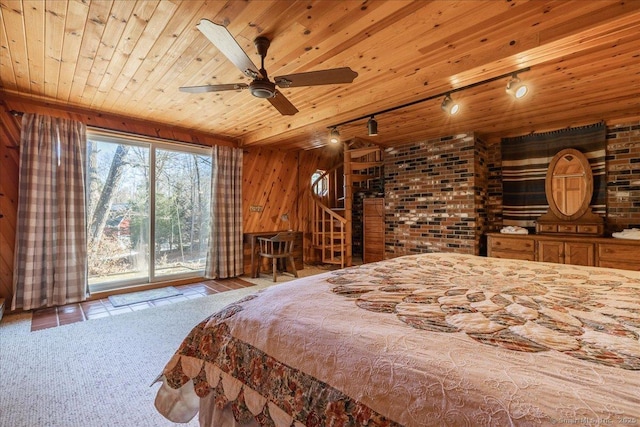 tiled bedroom with access to outside, wooden ceiling, wooden walls, and track lighting