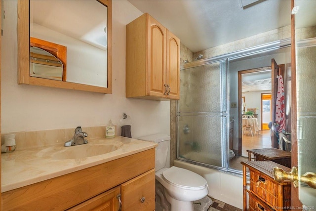 full bathroom with toilet, vanity, and bath / shower combo with glass door