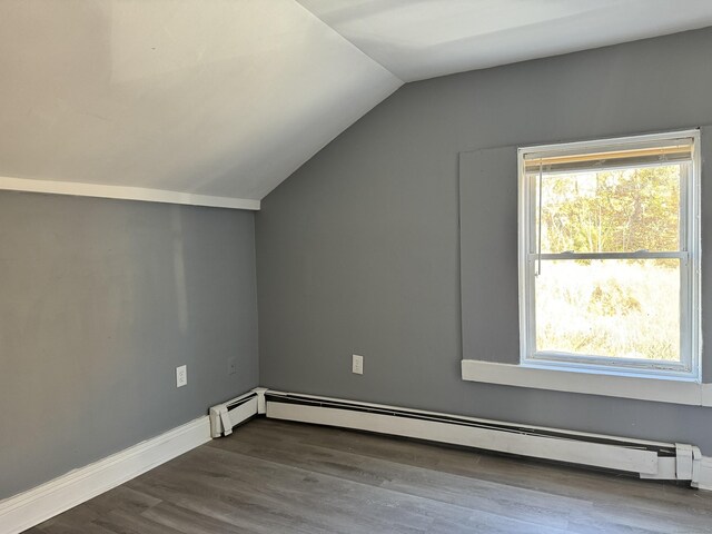 bonus room with lofted ceiling, a baseboard heating unit, and dark wood-type flooring