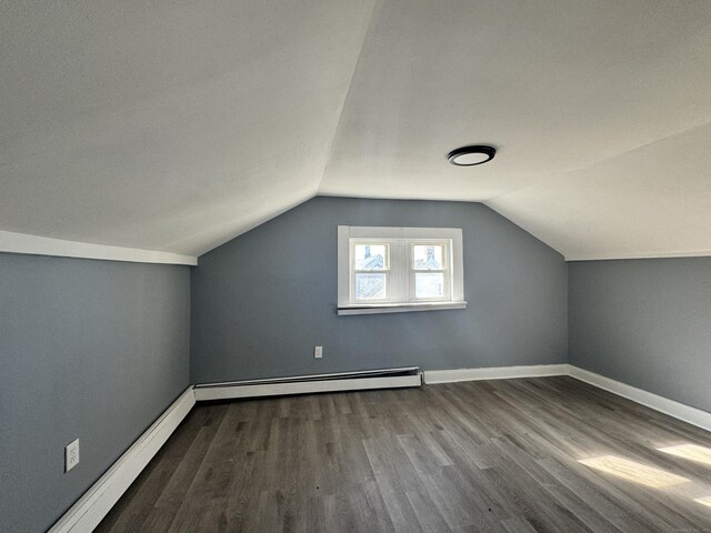 additional living space with lofted ceiling, hardwood / wood-style flooring, and a baseboard radiator