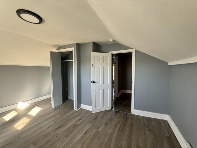 bonus room with lofted ceiling and dark hardwood / wood-style floors