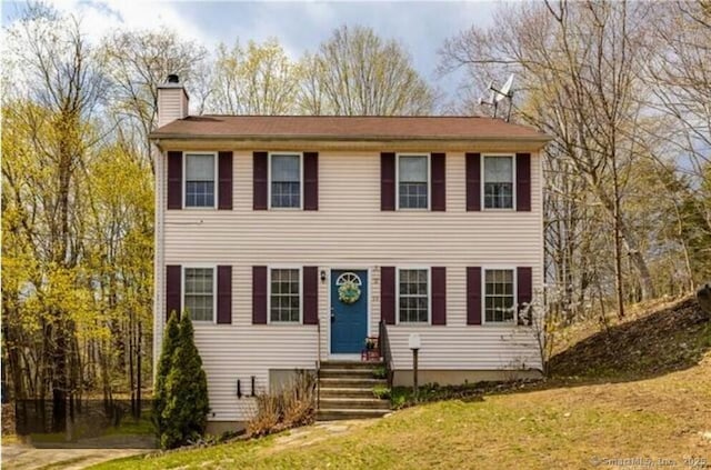 colonial house featuring a front yard