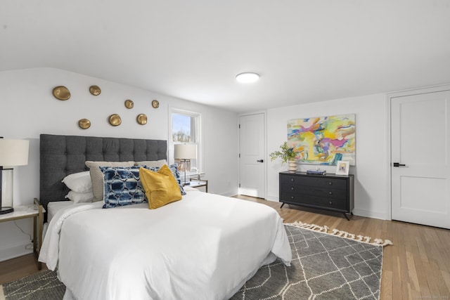 bedroom featuring hardwood / wood-style flooring and lofted ceiling