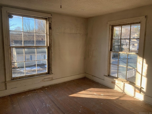 empty room featuring dark hardwood / wood-style flooring and a textured ceiling