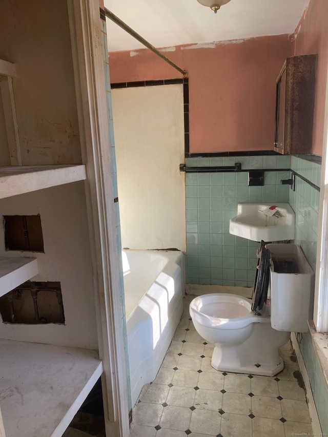 bathroom with washtub / shower combination, toilet, and tile walls