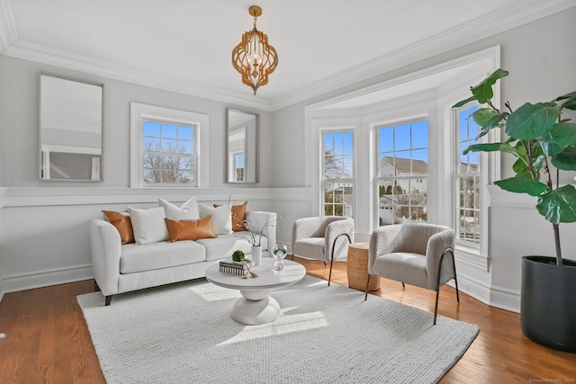 sitting room featuring dark wood-style floors, crown molding, and baseboards