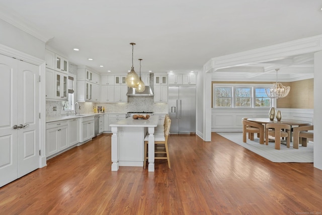 kitchen featuring a kitchen island, white cabinetry, light countertops, appliances with stainless steel finishes, and glass insert cabinets