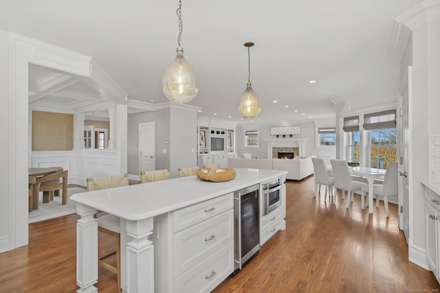 kitchen with beverage cooler, a breakfast bar area, open floor plan, and light countertops