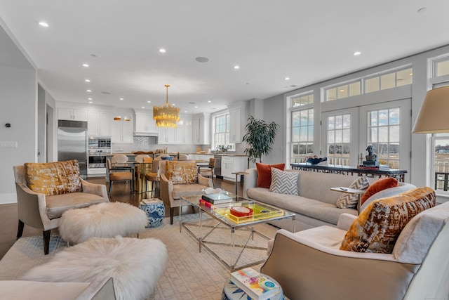 living room with french doors and a chandelier