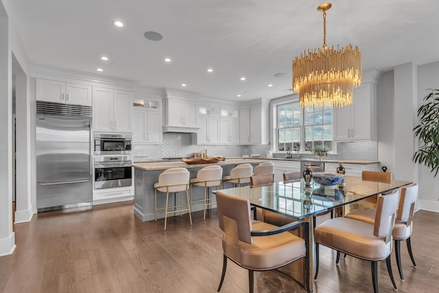 dining room featuring dark hardwood / wood-style floors, sink, and a chandelier