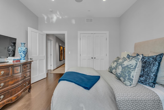 bedroom with hardwood / wood-style floors and a closet