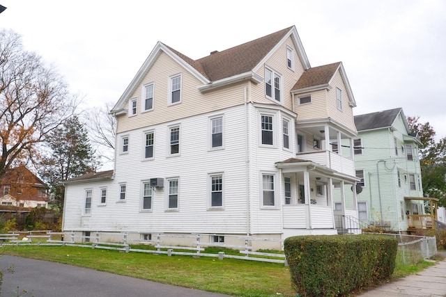 view of side of property featuring a lawn and an AC wall unit