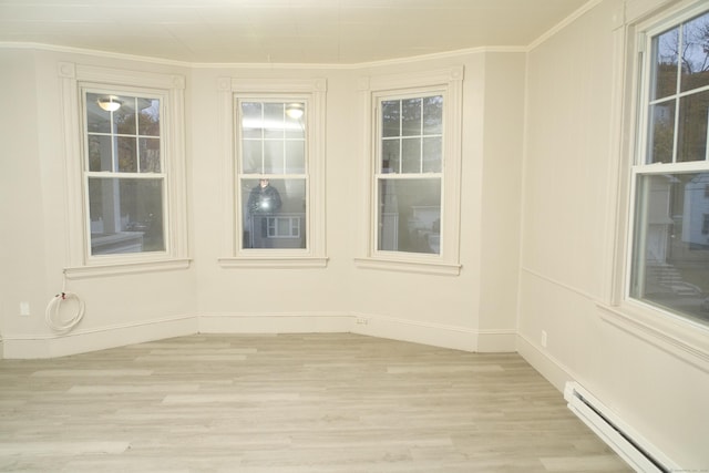 unfurnished room with crown molding, light hardwood / wood-style floors, and baseboard heating