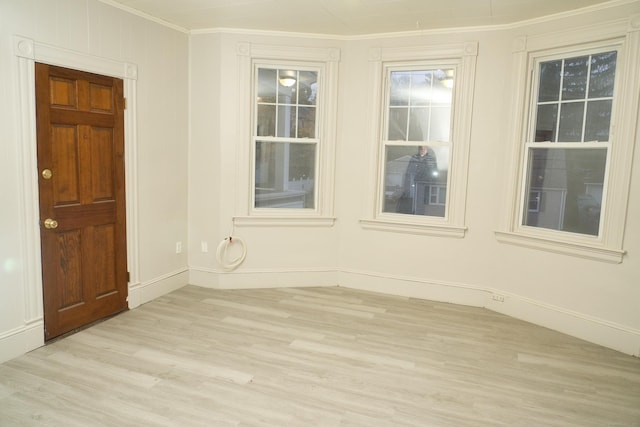 spare room with ornamental molding and light hardwood / wood-style flooring