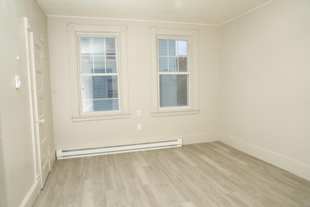 unfurnished room featuring a baseboard radiator and light hardwood / wood-style floors