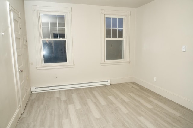 unfurnished room featuring a baseboard radiator and light hardwood / wood-style floors