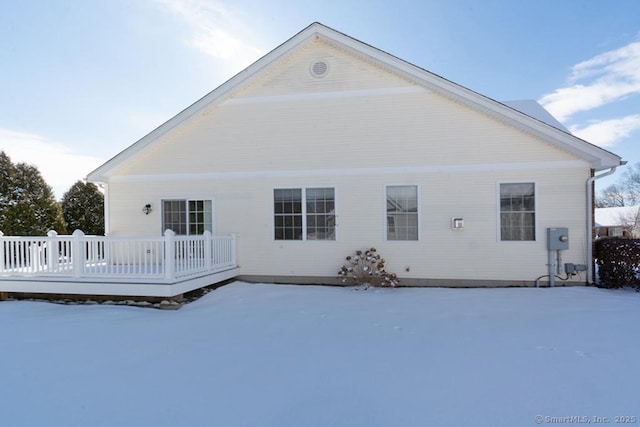 snow covered house with a wooden deck