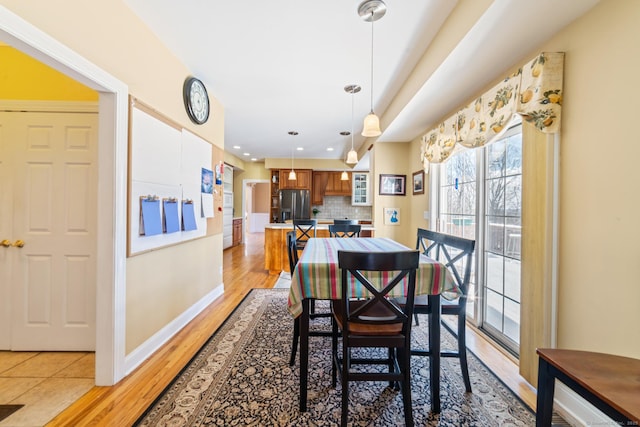 dining room with recessed lighting, baseboards, and light wood finished floors