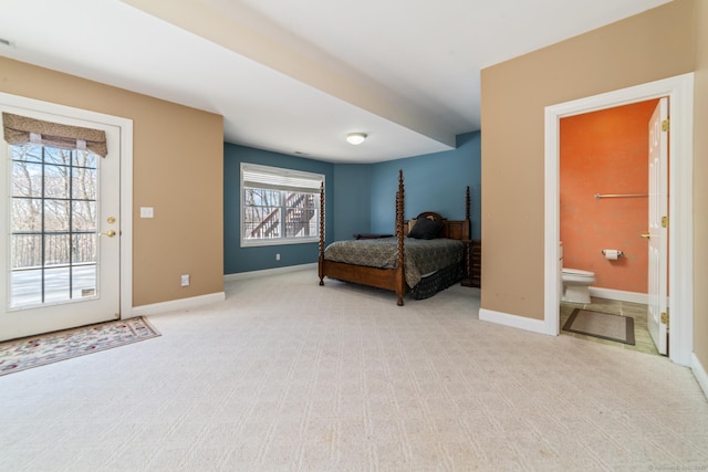 bedroom with baseboards, connected bathroom, and light colored carpet