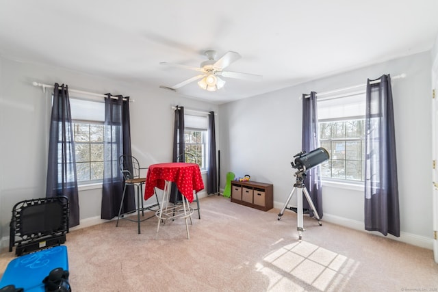 interior space with carpet flooring, a ceiling fan, and baseboards