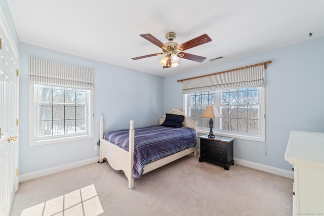 bedroom with baseboards, a ceiling fan, visible vents, and light colored carpet