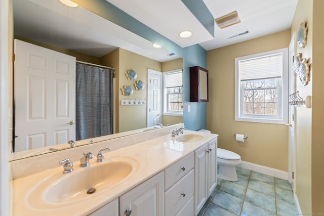 full bathroom with a healthy amount of sunlight, a sink, and toilet