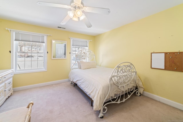 bedroom with a ceiling fan, visible vents, light carpet, and baseboards