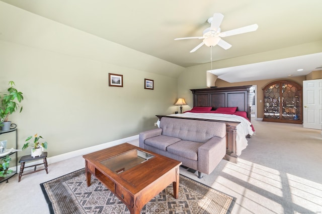 bedroom with a ceiling fan, light colored carpet, vaulted ceiling, and baseboards