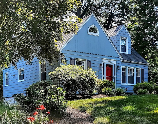 view of front facade with a front lawn and roof with shingles