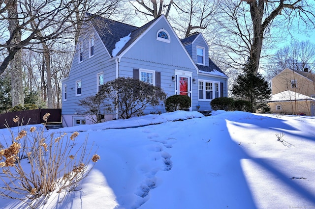 cape cod-style house with roof with shingles and fence