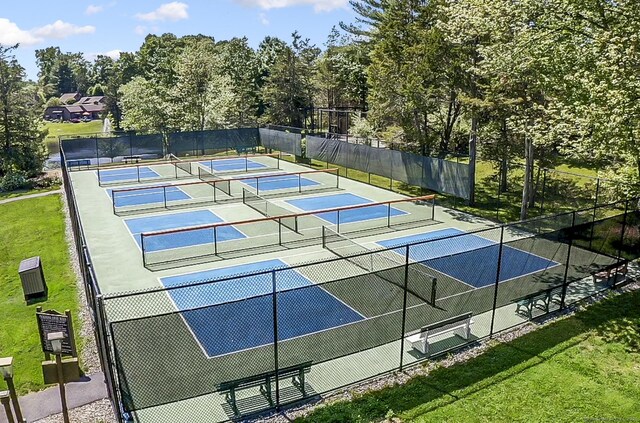 view of tennis court with a yard