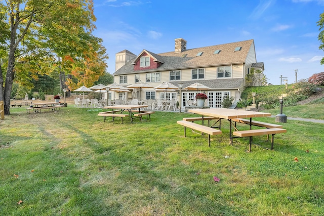 back of house featuring french doors and a lawn