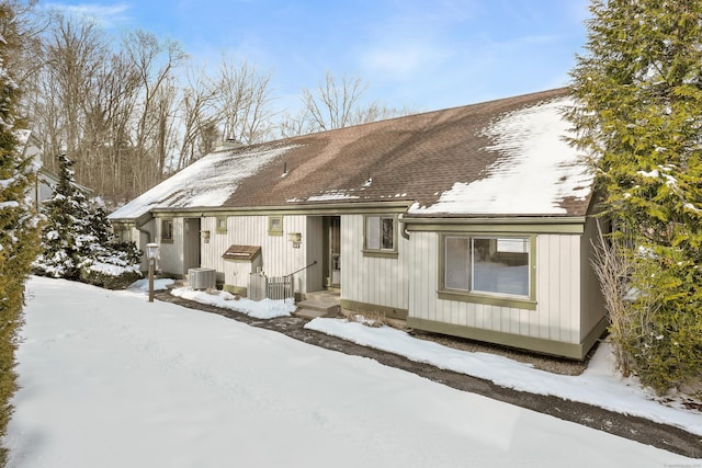 snow covered house with central AC unit