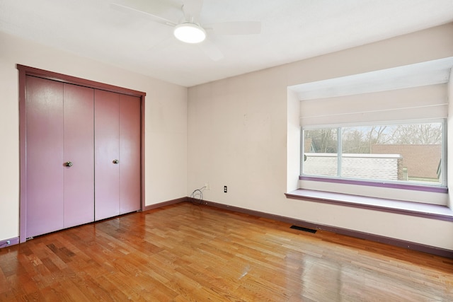 unfurnished bedroom featuring light hardwood / wood-style flooring, a closet, and ceiling fan