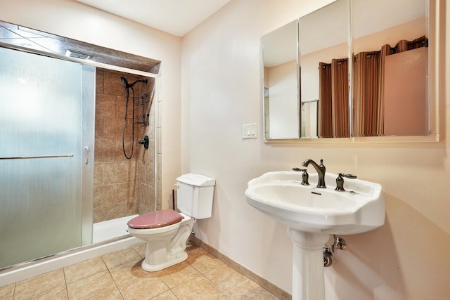 bathroom featuring a shower with door, tile patterned floors, and toilet