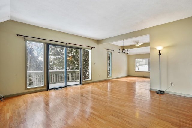 unfurnished room featuring an inviting chandelier and light wood-type flooring