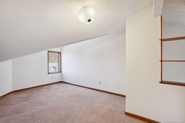 bonus room with carpet, vaulted ceiling, and a textured ceiling