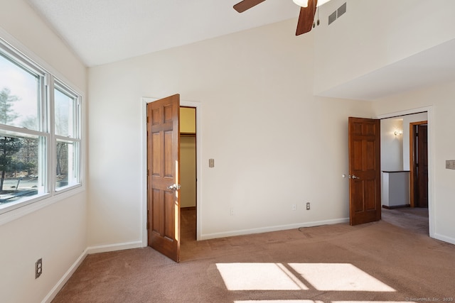 unfurnished bedroom featuring visible vents, baseboards, vaulted ceiling, and light colored carpet