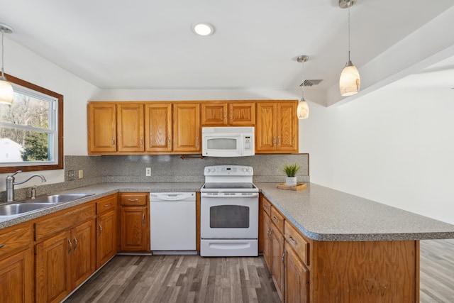 kitchen with visible vents, backsplash, a sink, white appliances, and a peninsula