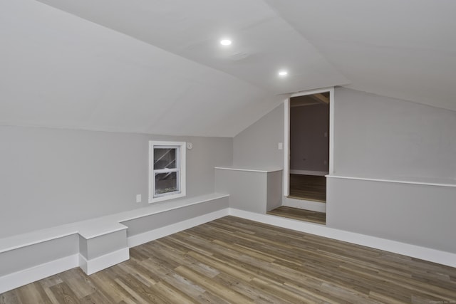 additional living space featuring lofted ceiling and hardwood / wood-style flooring